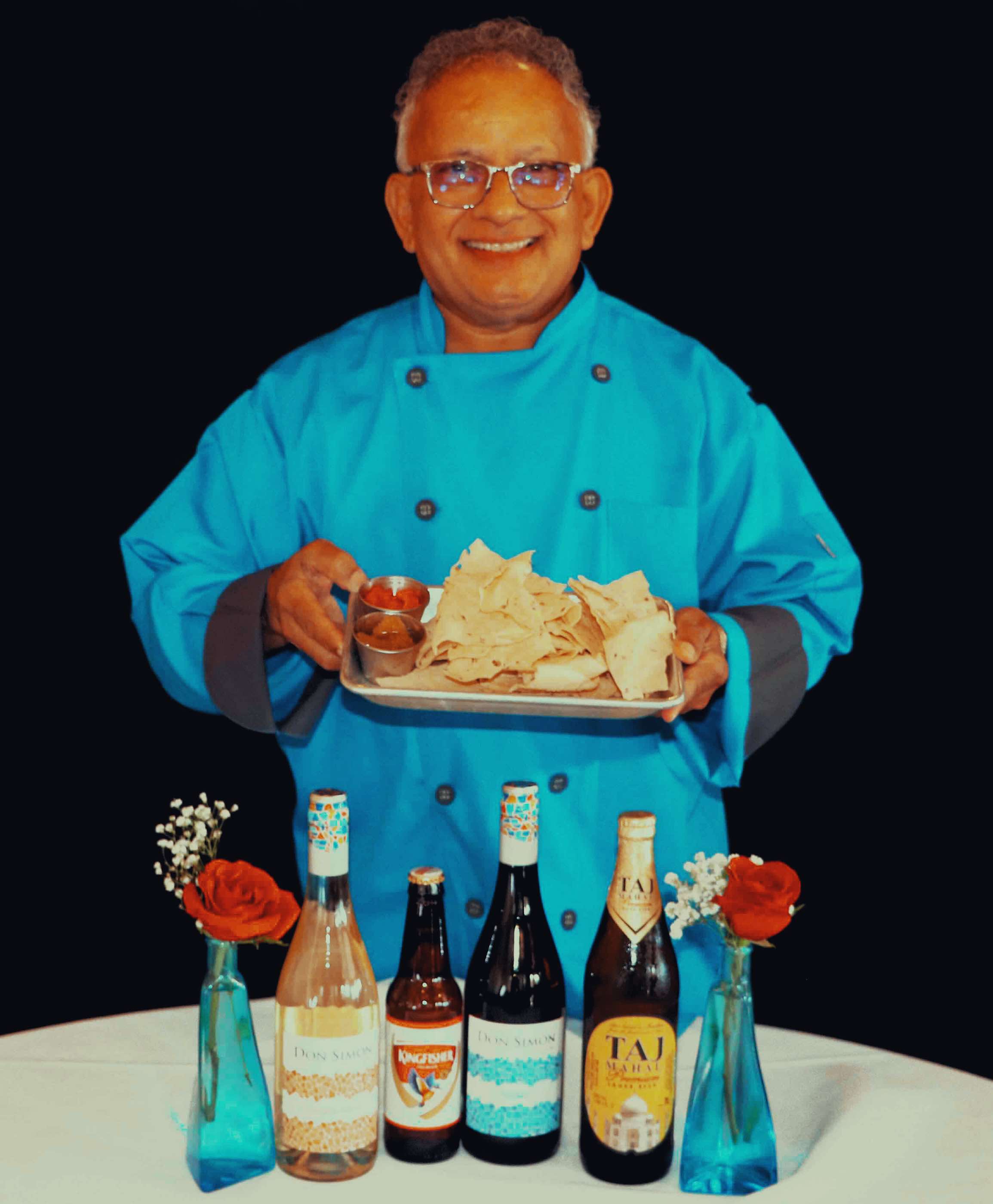 Guru Restaurant's Chef and Owner Uday Kadam holding appetizers and drinks available at Guru